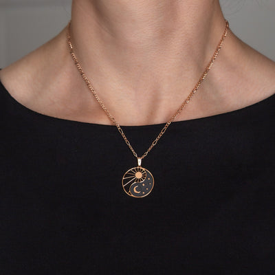 Halskette Yin Yang Cosmique Laque Noir Atelier-Émile, 18 Karat Roségold plattiert mit 24 Karat Finish, 10 bis 15 Mikron dickes Plattierungsmaterial, hergestellt in der Schweiz, montiert auf einer Figaro-Kette, getragen, Ansicht von vorne auf schwarzem Hintergrund