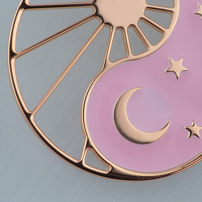Halskette Yin Yang Cosmique Atelier-Émile, 18 Karat Roségold plattiert, rosa Lack, Makrobild auf weißem Hintergrund