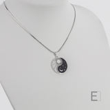 Halskette Yin Yang Cosmique Schwarzer Lack, Schlangenkette, Atelier-Émile aus Rhodium, plattiert  in der Schweiz, Vorderansicht auf weißem Hintergrund