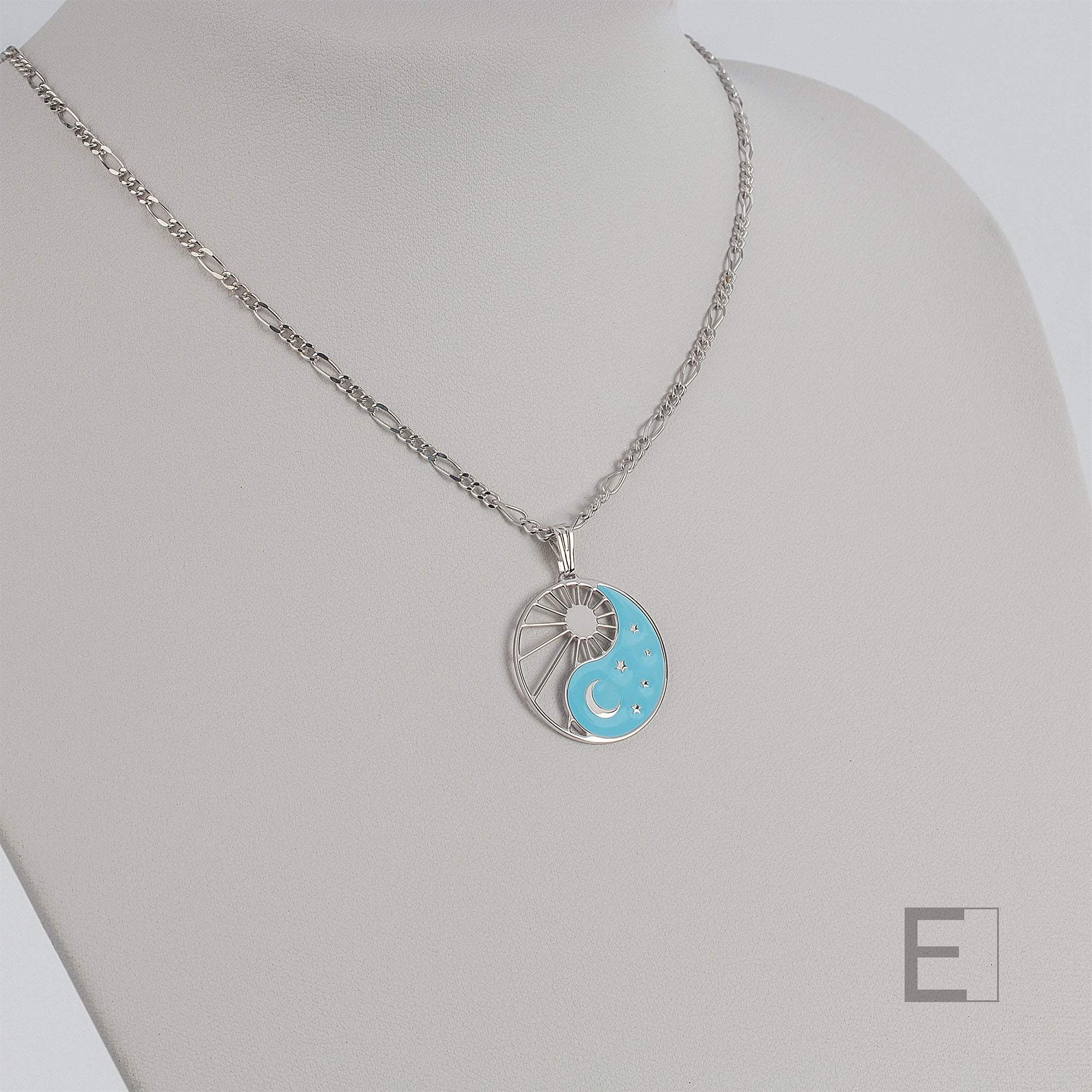 Halskette Yin Yang Cosmique Leuchtend blaue Lackierung, Figaro-Kette von Atelier-Émile aus Rhodium, Beschichtung  hergestellt in der Schweiz, Ansicht von vorne auf weißem Hintergrund