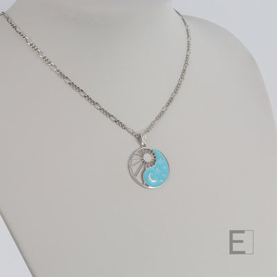 Halskette Yin Yang Cosmique Leuchtend blaue Lackierung, Figaro-Kette von Atelier-Émile aus Rhodium, Beschichtung  hergestellt in der Schweiz, Ansicht von vorne auf weißem Hintergrund
