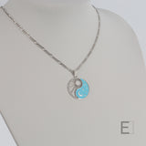 Halskette Yin Yang Cosmique Leuchtend blaue Lackierung, Figaro-Kette von Atelier-Émile aus Rhodium, Beschichtung  hergestellt in der Schweiz, Ansicht von vorne auf weißem Hintergrund