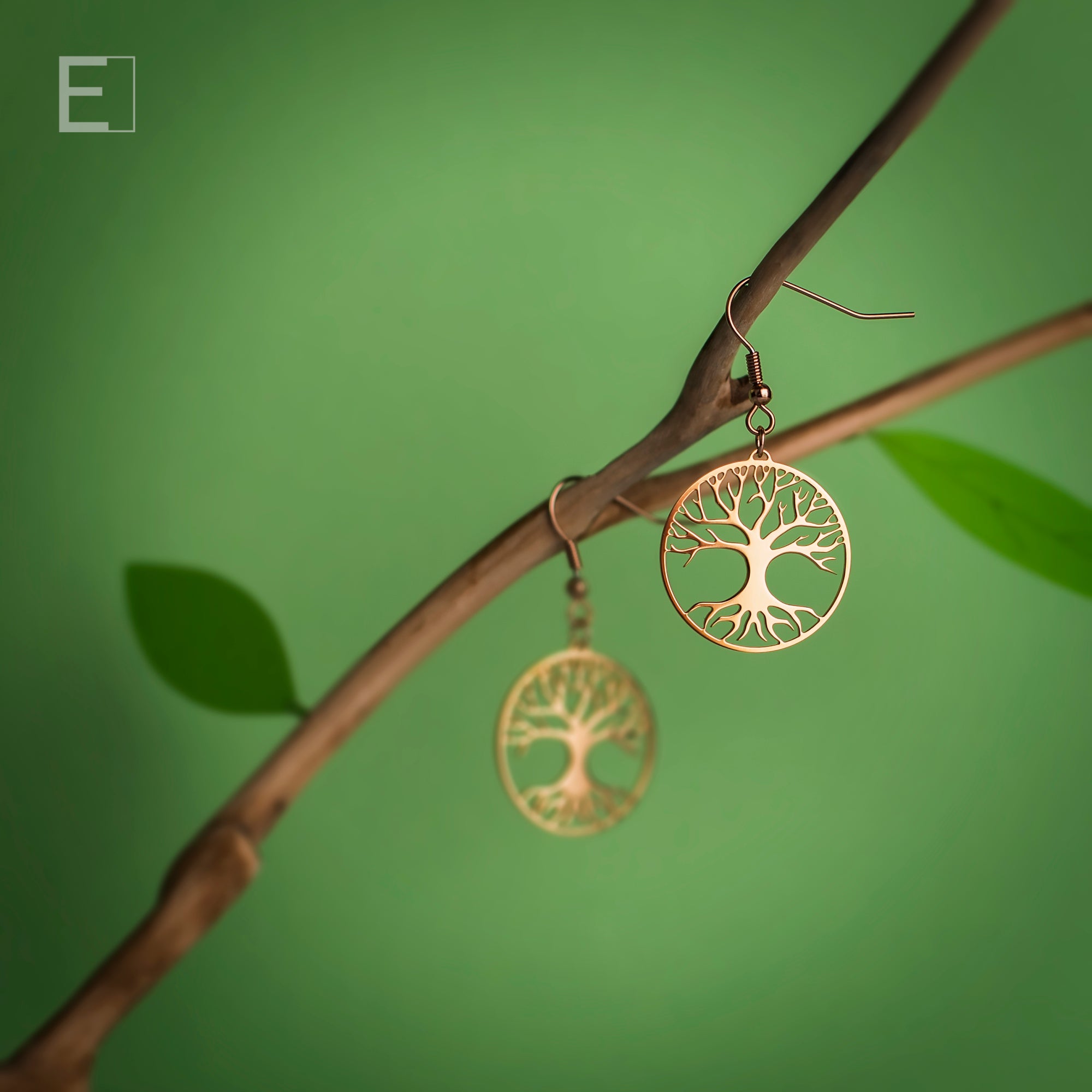 Boucles d’oreilles Arbre de Vie en plaqué or rose suspendues dans un décor végétal – Atelier-Émile